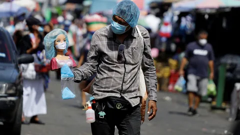 AME8021. SAN SALVADOR (EL SALVADOR), 13/08/2020.- Un hombre que se dedica al comercio informal vende gorros quirúrgicos el 22 de julio de 2020, en San Salvador (El Salvador). Tras cinco meses de confinamiento e intentos de desescalada, Centroamérica sufre un recrudecimiento de la pandemia, con Panamá como el peor escenario, en medio de un creciente deterioro económico y social en una región afectada por una extrema pobreza crónica. EFE/Rodrigo Sura
