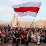 Una mujer biolorrusia ondea la histórica bandera blanca y roja en una protesta en la Plaza de la Independencia de Minsk