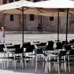 Una persona recorre la Plaza de la Virgen de Valencia junto a sus terrazas prácticamente desiertas