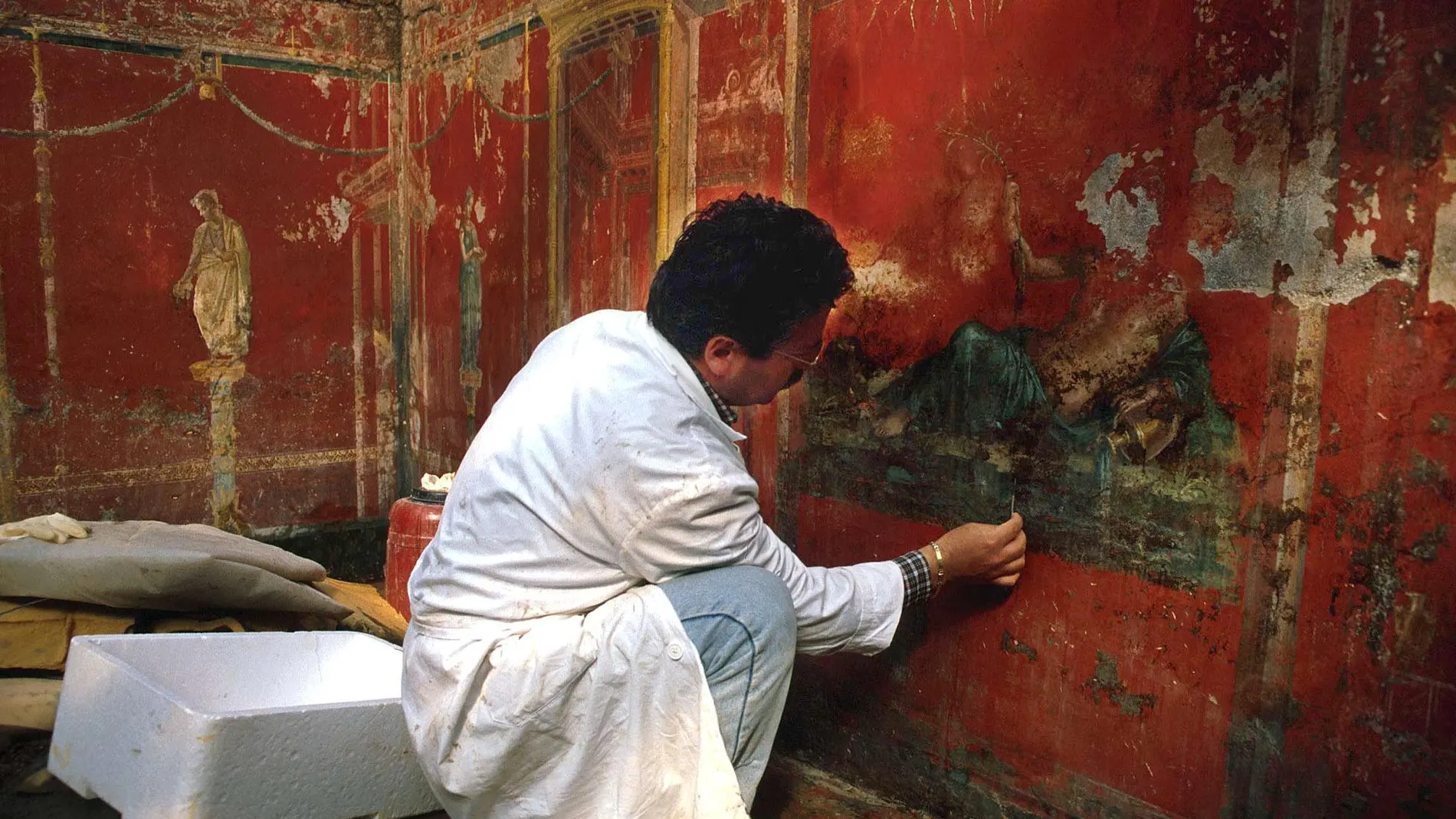 Un arqueólogo trabaja en una de las pinturas conservadas en Pompeya
