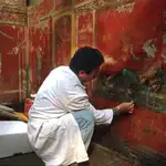 Un arqueólogo trabaja en una de las pinturas conservadas en Pompeya