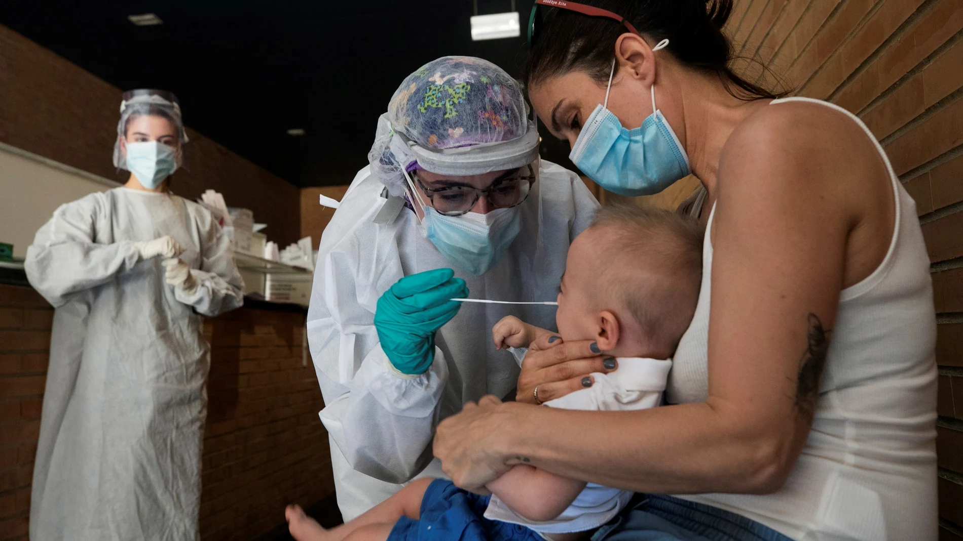 Un sanitario realiza una prueba PCR a un niño en un espacio habilitado en un centro de salud de Zaragoza