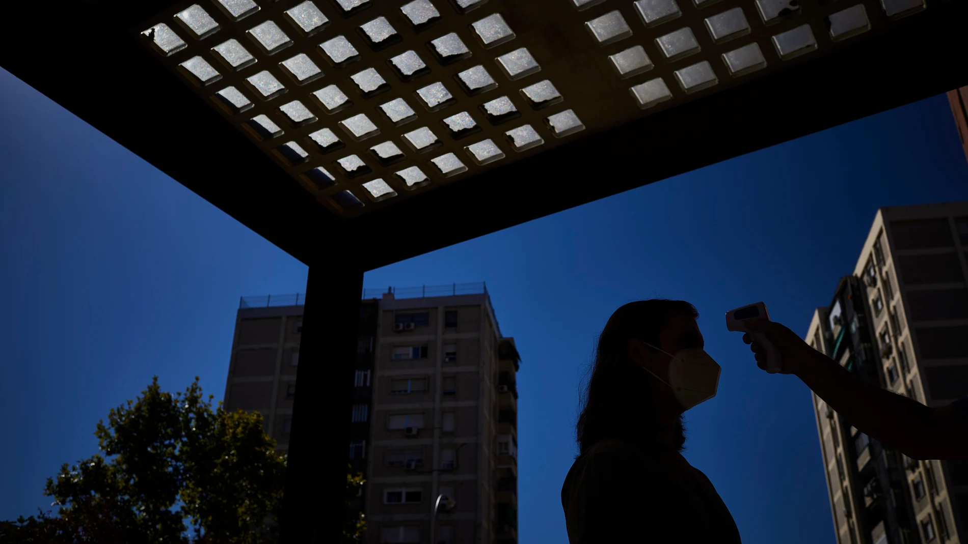 Un ciudadano se somete a un control de temperatura a las puertas del centro de salud de Villaverde, en Madrid