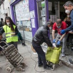Filas de personas sin recursos económicos hacen cola para que la Asociación de Vecinos de Aluche, sita en la calle Quero, les proporcione productos alimenticios
