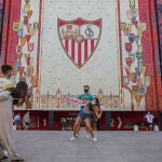 Varias personas se fotografían ante el escudo del Sevilla FC durante las horas previas al partido final de la Europa League Sevilla FC - Inter de Milán, en las inmediaciones del estadio Ramón Sánchez Pizjuán.