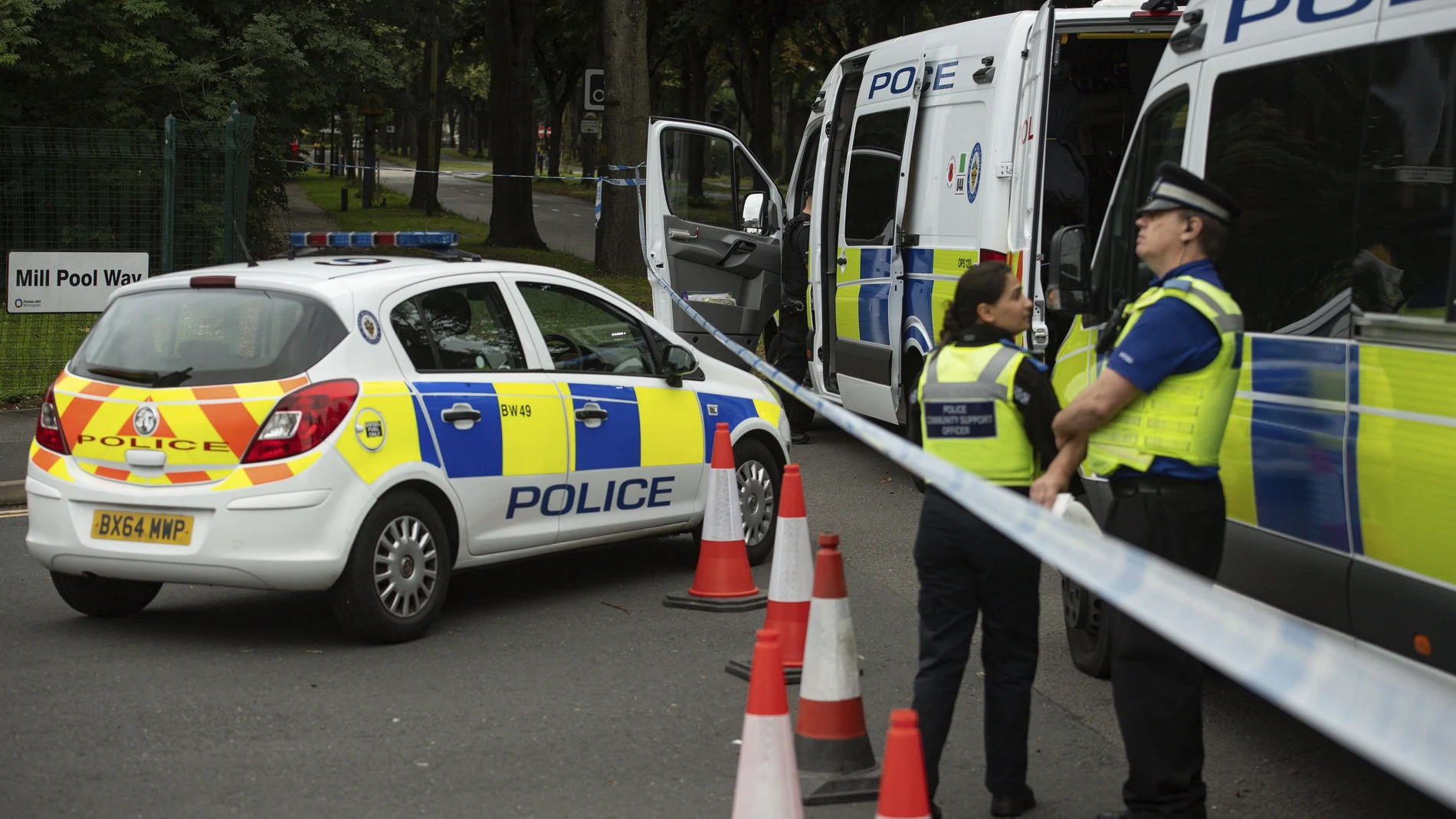 Police officers secure the area after a man was found fatally stabbed late Saturday, in Birmingham, England, Sunday Aug. 23, 2020. A 15-year-old girl and a 28-year-old woman were detained at the scene and according to the police, they remain in custody. (Jacob King/PA via AP)