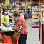 En la imagen, una señora compra en un supermercado