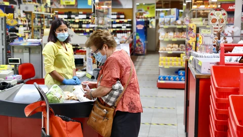 En la imagen, una señora compra en un supermercado