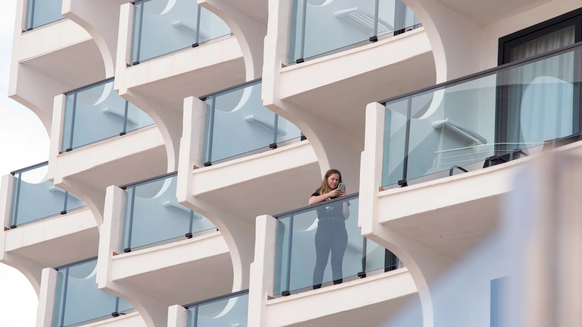 Una turista en la terraza de un hotel abierto en la playa de Palma de Mallorca