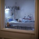 A patient with COVID-19 lies on a bed at the Eurnekian Ezeiza Hospital in Buenos Aires, Argentina, Thursday, Aug. 13, 2020. At a time when the number of deaths due to COVID-19 has increased in Argentina, some hospitals are now allowing persons, fully decked out in protective gear, to accompany their dying relatives. (AP Photo/Natacha Pisarenko)