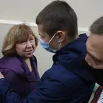 La escritor bielorrusa ganadora del Premio Nobel, Svetlana Alexievich, pasa junto a un oficial de policía al llegar al Comité de Investigación de Bielorrusia en Minsk para ser interrogada.