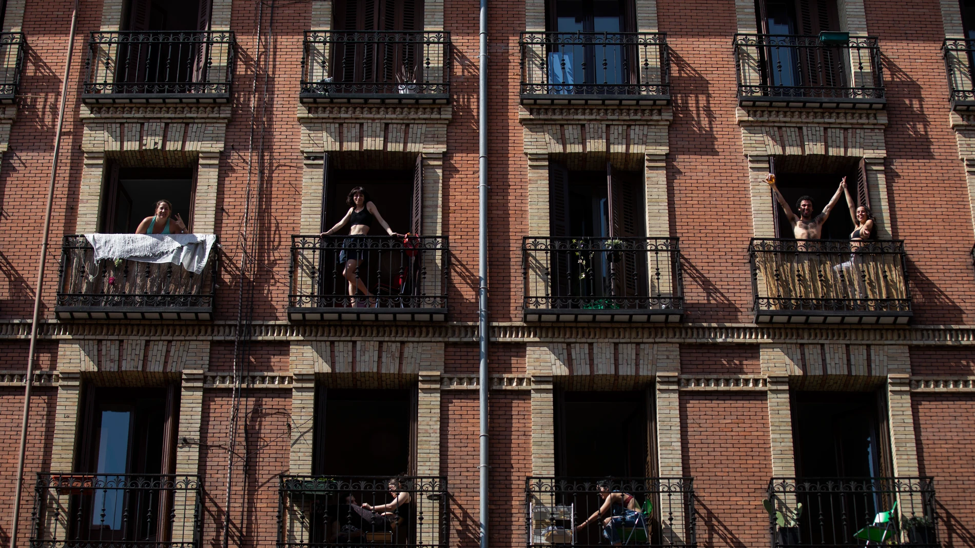 Vecinos de un edificio de Madrid en sus balcones durante el confinamiento por la epidemia de coronavirus