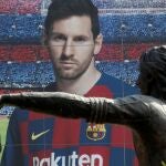 La estatua de Johan Cruyff, enfrente de una imagen de Messi en el Camp Nou