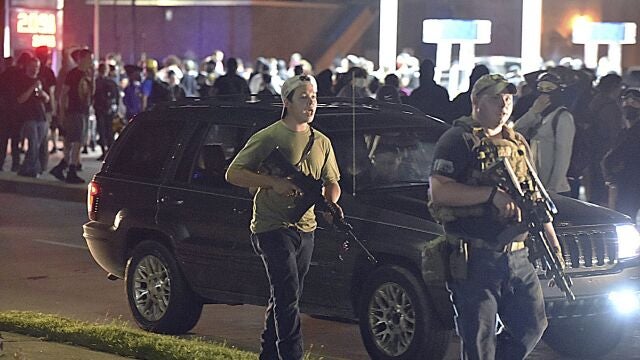 Kyle Rittenhouse, a la izquierda con un rifle de asalto con otro compañero camino por la calle Sheridan de Kenosha en Wisconsin