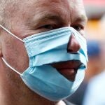 Un manifestante lleva una mascarilla rota por la nariz y la boca en la protesta contra las medidas del coronavirus
