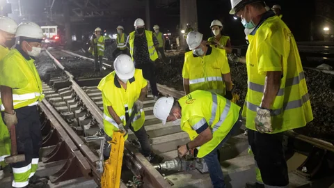 Varios operarios trabajan en las obras que Adif está ejecutando para la nueva configuración del esquema de vías de ancho de vía convencional de la estación de Barcelona-Sants
