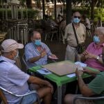 Un grupo de jubilados con mascarilla juega este verano a las cartas en un parque de Gran Canaria