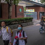 Beijing (China), 31/08/2020.- Students wearing protective face masks leave a school after classes, in Beijing, China, 31 August 2020. Schools in Beijing are opening for the fall semester in a phased way from 29 August to 07 September following stringent anti-coronavirus conditions. (Abierto) EFE/EPA/ROMAN PILIPEY