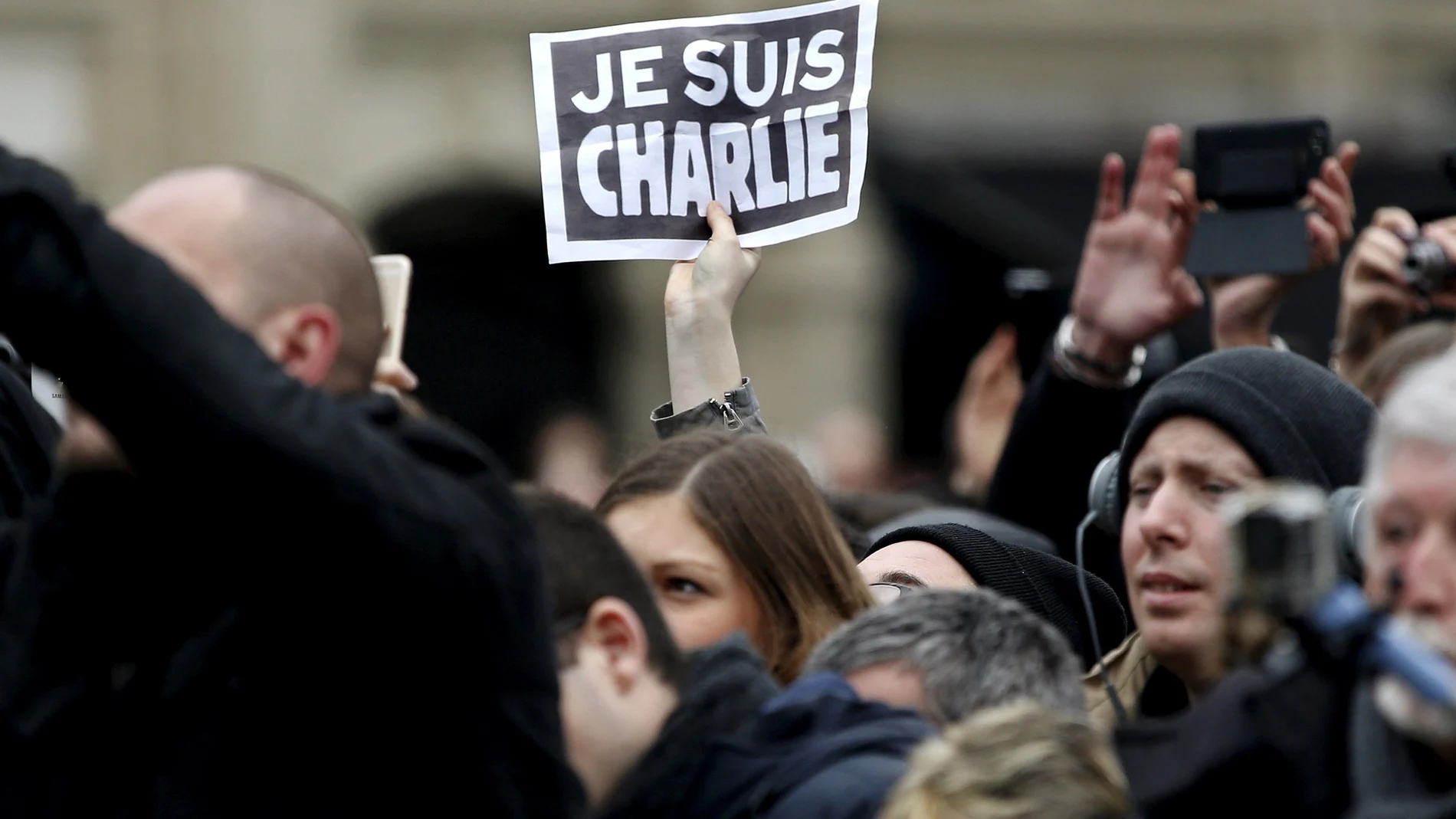 FILE PHOTO: Person holds up a sign during a ceremony at Place de la Republique square to pay tribute to the victims of last year's shooting at the French satirical newspaper Charlie Hebdo, in Paris