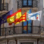 Banderas de la UE, España, Comunidad Valenciana y Caixa ondeando en los balcones de la sede de Caixabank, en Valencia.