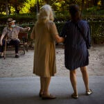 Una persona mayor descansa en un banco del madrileño parque de El Retiro