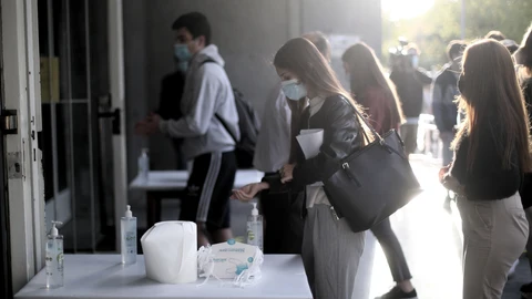 Una alumna se desinfecta las manos antes de entrar al aula de examen de la Facultad de Derecho de la Universidad Complutense para examinarse de la EVAU