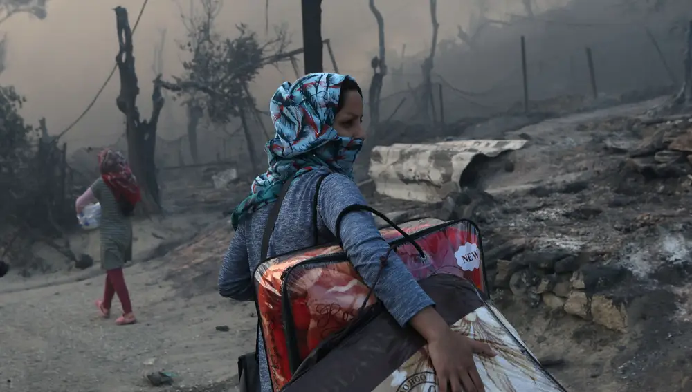 Una mujer se lleva sus pertenencias tras el incendio