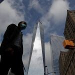 A man wearing a protective face mask walks by One World Trade Center two days before the 19th anniversary of the 9/11 attacks, amid the coronavirus disease (COVID-19) pandemic, in the lower section Manhattan, New York City, U.S., September 9, 2020. REUTERS/Shannon Stapleton