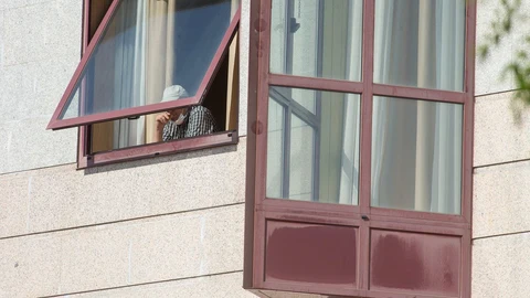 Un anciano se asoma a una venta en una residencia
