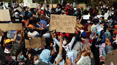 Refugiados levantan carteles con el lema" Alemania ayúdanos ",en el campamento de Kara Tepe en Lesbos , Grecia.