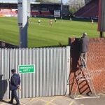 Paul Taylor viendo el Crewe Alexandra-Charlton subido a una escalera.