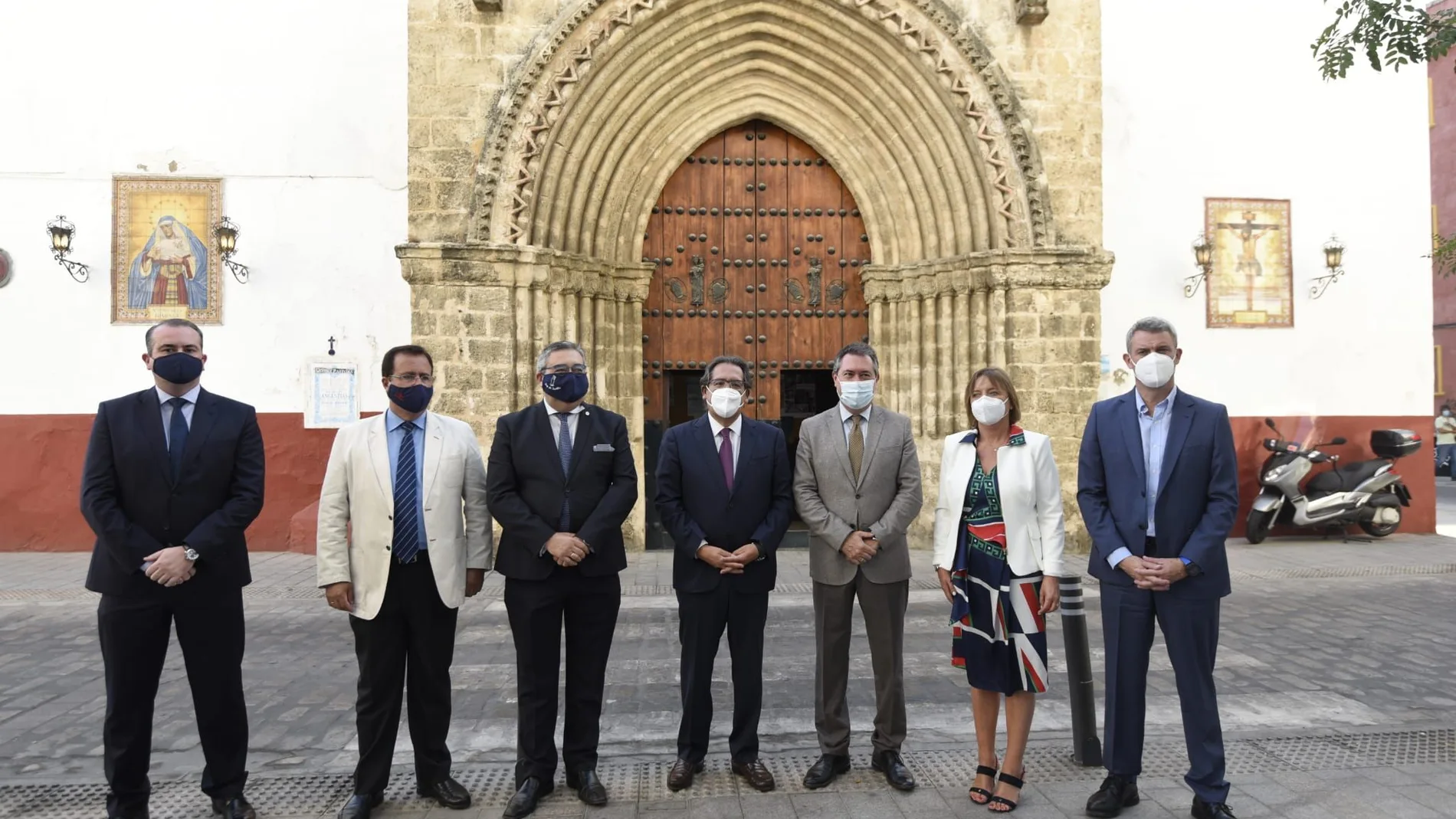 Representantes del Ayuntamiento de Sevilla, de las fundaciones Cajasol y "la Caixa" y de la hermandad de la Hiniesta de Sevilla, frente a la parroquia de San Julián