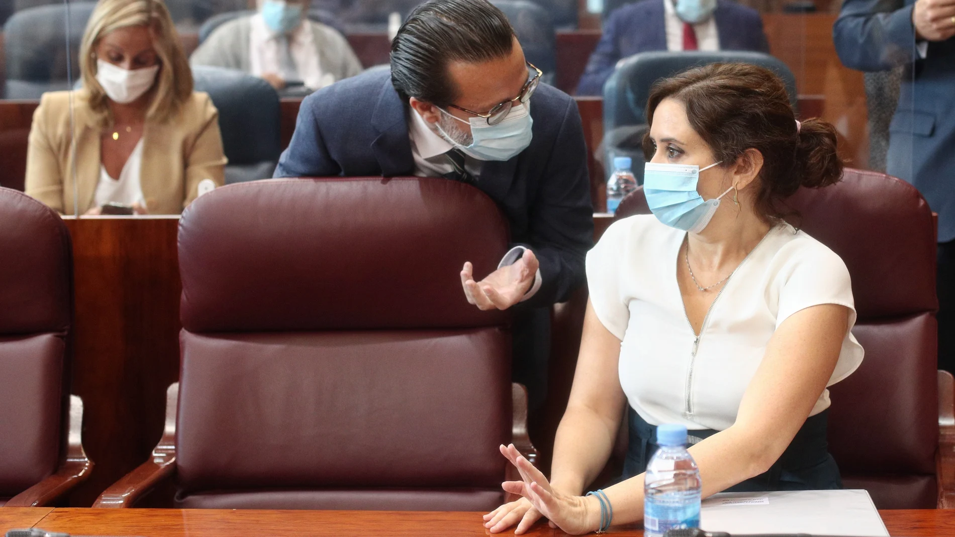 El consejero de Hacienda y Función Pública, Javier Fernández-Lasquetty, habla con la presidenta de la Comunidad de Madrid, Isabel Díaz Ayuso, en la Asamblea de Madrid.