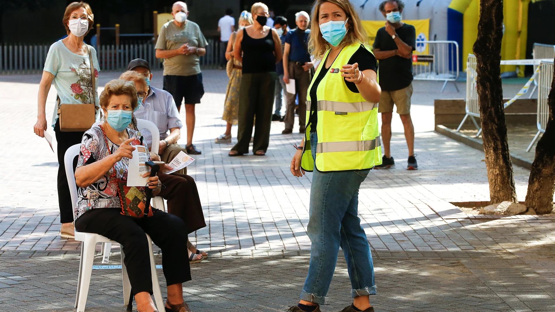 Varias personas esperan para acceder a la zona de realización de PCR durante el primer día de cribados masivos de Covid-19 en El Raval de Barcelona. EFE/Quique Garcia