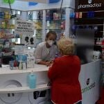 Una vecina del distrito del Puente de Vallecas compra en una farmacia en la Avenida de la Albufera.