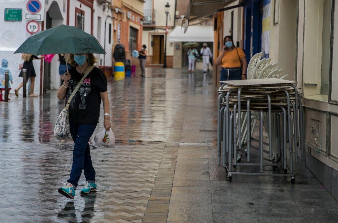 Una mujer se protege de la lluvia bajo su paraguas 