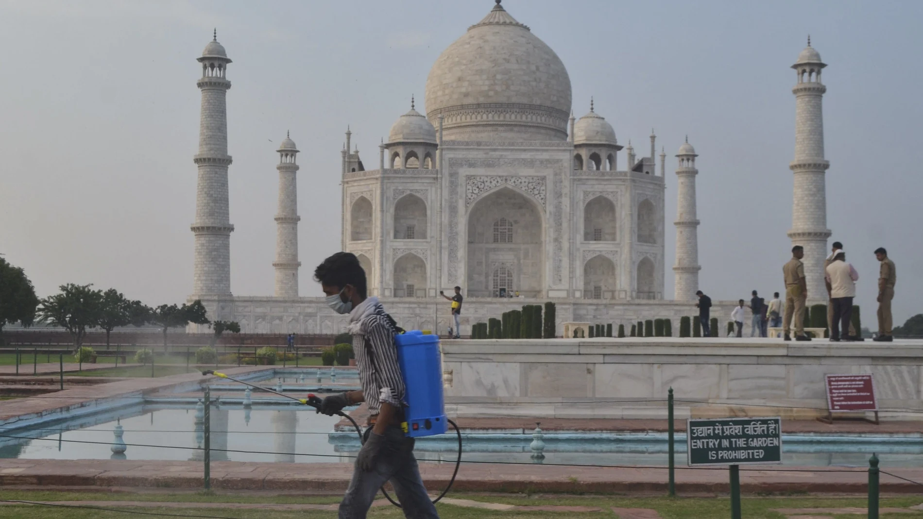 Un hombre desinfecta las afueras del Taj Mahal en la India