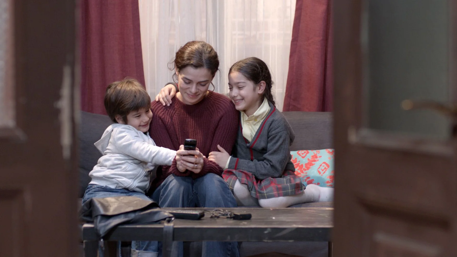 Bahar (Ozge Ozpirincci) recupera el móvil de su marido y muestra a sus hijos las fotos guardadas