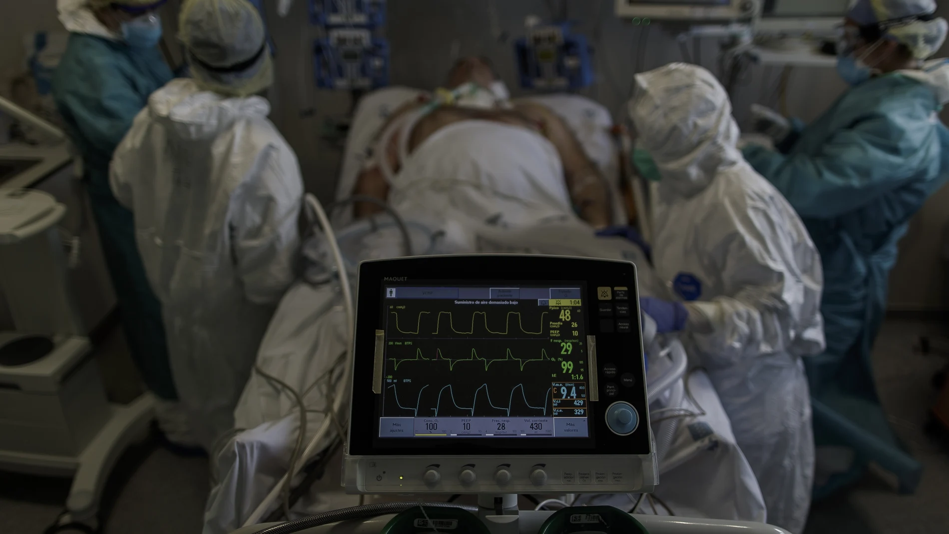 Personal sanitario totalmente protegido atiende a un paciente ingresado en la Unidad de Cuidados Intensivos del Hospital Infanta Sofía en San Sebastián de los Reyes.