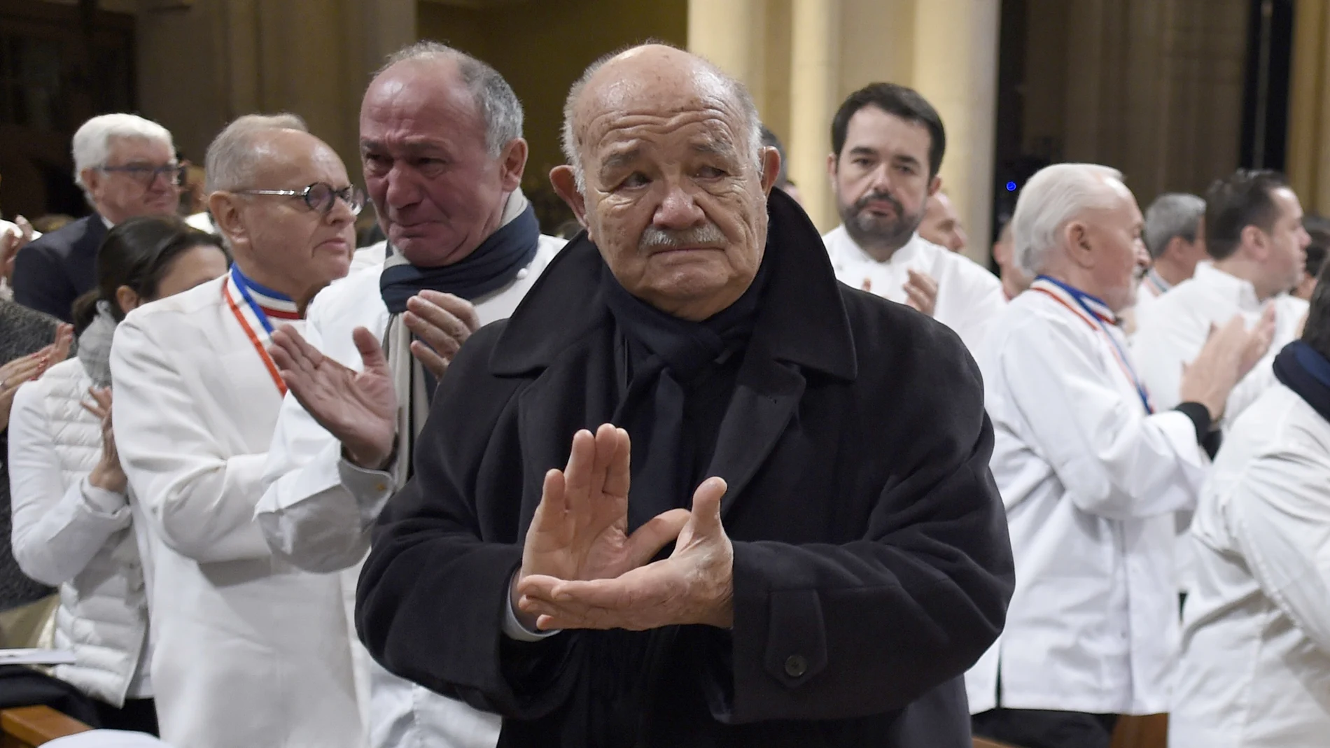FILE - In this Friday, Jan. 26, 2018 file photo, French chef Pierre Troisgros applauds as the coffin of late French chef Paul Bocuse leaves the Saint-Jean Cathedral, in Lyon, central France. French media say Pierre Troisgros, one of Franceâ€™s top chefs who helped reinvent the countryâ€™s traditional cuisine, has died. He was 92. The French press quoted the head of the Maison Troisgros, Patrice Laurent, saying the chef died Wednesday, Sept. 23, 2020 at his home in Coteau, near Roanne in the Loire region where his restaurant is located. (Philippe Desmazes/Pool Photo via AP, file)