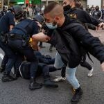 Miembros de la policía antidisturbios cargan contra un grupo de manifestantes que protestaban en favor de la Sanidad Pública y contra los confinamientos selectivos, este jueves en Madrid.