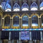 Varias pantallas muestran la evolución del IBEX 35 en el Palacio de la Bolsa en Madrid