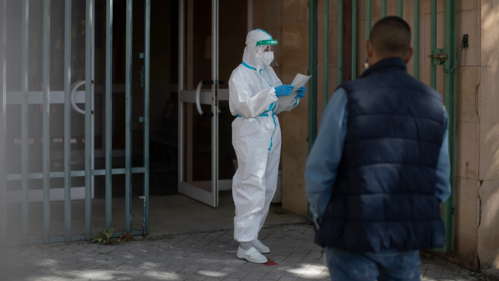 Una trabajadora sanitaria sale protegida de arriba abajo de un centro de salud perteneciente a la zona básica de salud de Paraderas en la localidad de Fuenlabrada