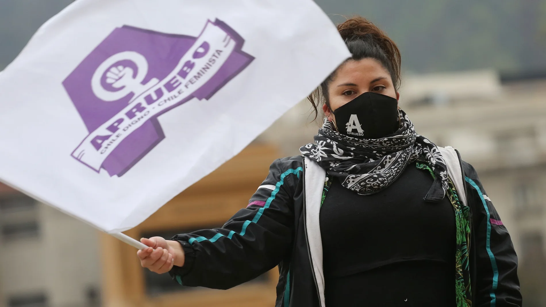 Una mujer con mascarilla participa en una manifestación llamada "banderazo por el Apruebo" en Santiago de Chile