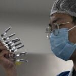 Un empleado inspecciona manualmente viales de la vacuna china SinoVac, en la fábrica de la compañía en Beijing (China)