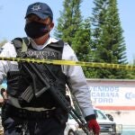 Un oficial de policía ayuda a resguardar las inmediaciones de un bar donde asesinaron a al menos once personas en México