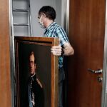 Un operario del Parlamento de Navarra retira un retrato de Juan Carlos I el pasado mes de junio