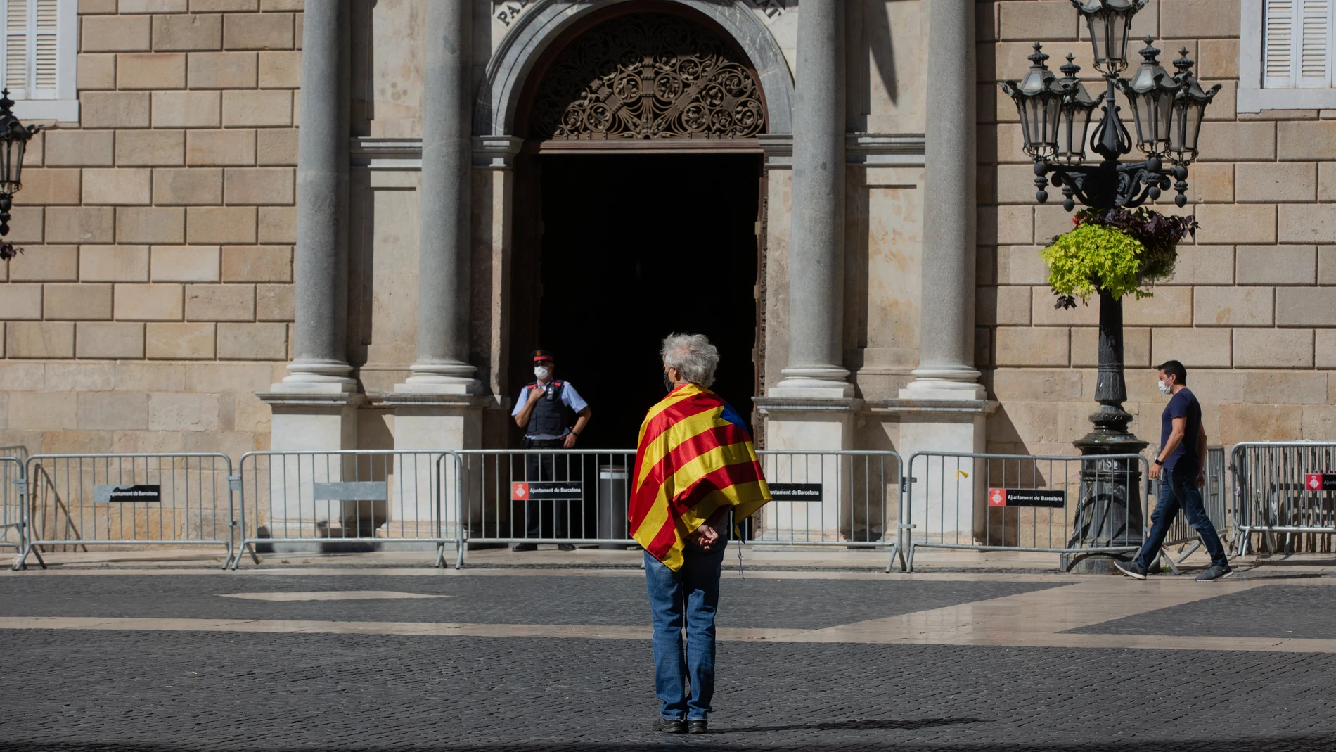 Un hombre envuelto en una estelada frente al Palau de la Generalitat