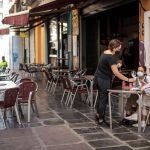 Una camarera atiende una mesa de una terraza en el centro de València