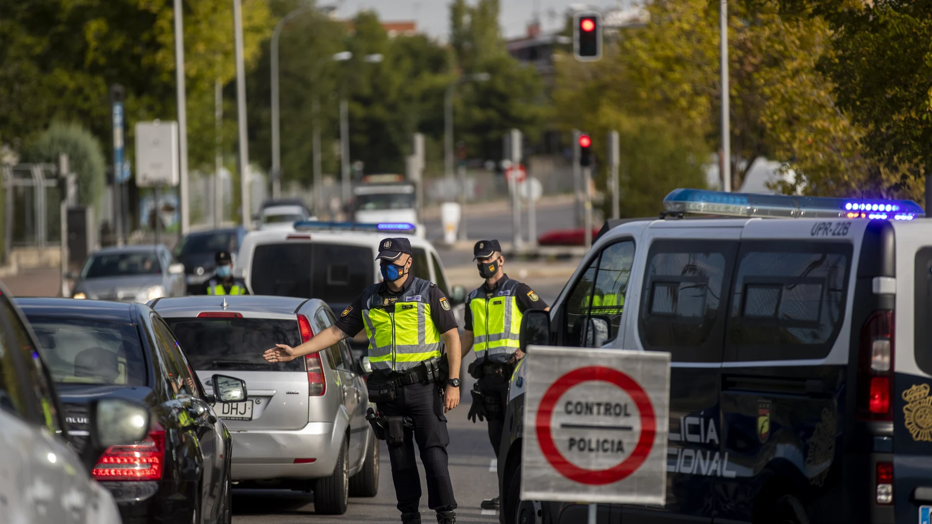 Agentes de la Policía Nacional detienen a los automóviles en un puesto de control en el barrio de Orcasitas, Madrid